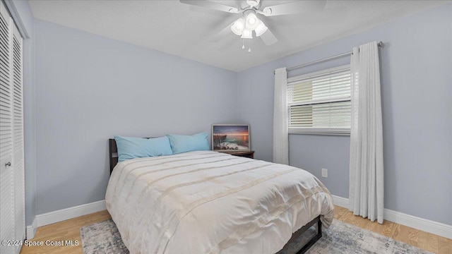 bedroom featuring hardwood / wood-style floors, a closet, and ceiling fan