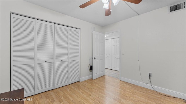 unfurnished bedroom with ceiling fan, a closet, and light hardwood / wood-style floors