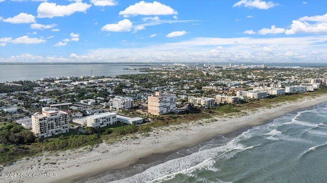 birds eye view of property with a water view and a beach view