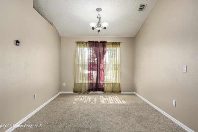 unfurnished room featuring carpet flooring, an inviting chandelier, and a textured ceiling