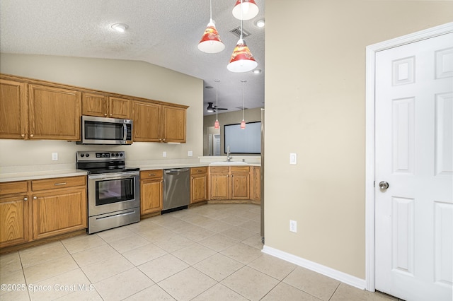 kitchen featuring light tile patterned floors, sink, hanging light fixtures, stainless steel appliances, and vaulted ceiling