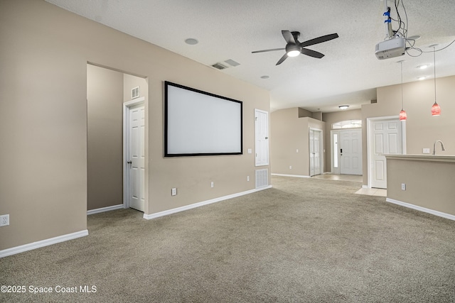 carpeted cinema with sink, a textured ceiling, and ceiling fan