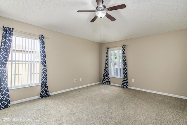 empty room with ceiling fan, a textured ceiling, and carpet