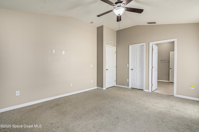 unfurnished bedroom featuring connected bathroom, vaulted ceiling, light carpet, and a textured ceiling