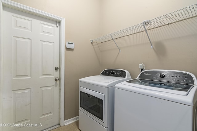 clothes washing area with light tile patterned flooring and independent washer and dryer