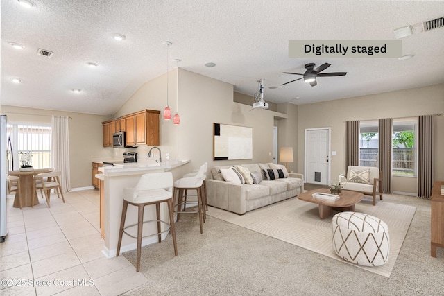 tiled living room featuring lofted ceiling, sink, a textured ceiling, and ceiling fan