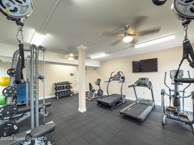 gym featuring a textured ceiling and ceiling fan