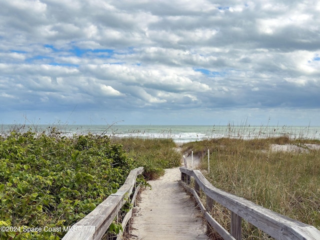 view of property's community with a beach view and a water view