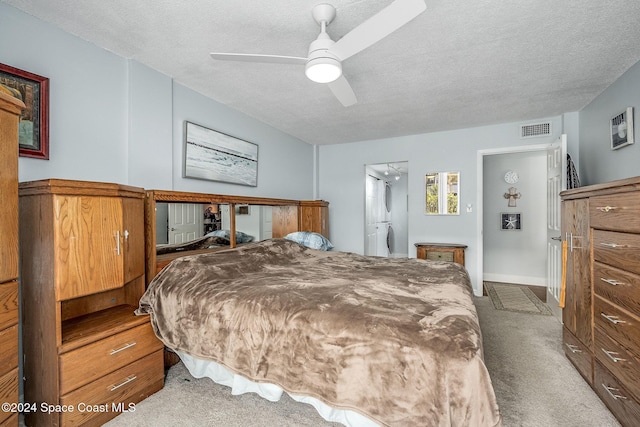 carpeted bedroom with ceiling fan and a textured ceiling