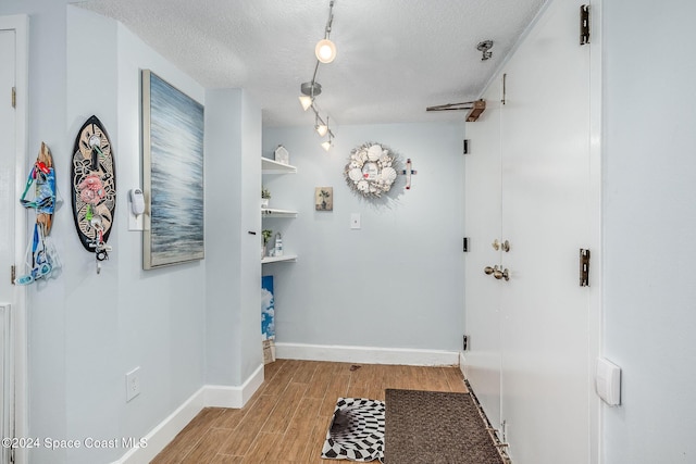 hall featuring a textured ceiling and light hardwood / wood-style flooring