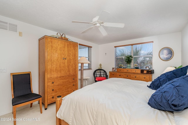 bedroom featuring a textured ceiling, carpet floors, and ceiling fan