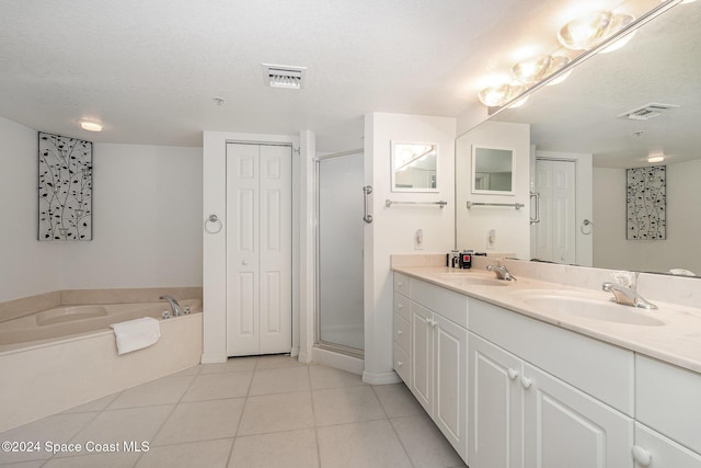 bathroom featuring tile patterned floors, vanity, a textured ceiling, and shower with separate bathtub