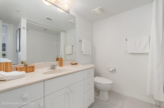 bathroom with tile patterned flooring, vanity, toilet, and a textured ceiling