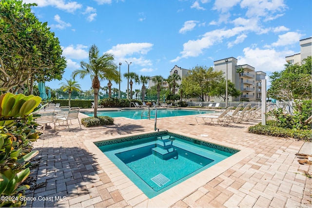 view of pool with a hot tub and a patio area