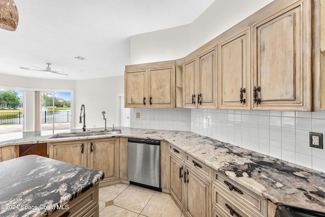 kitchen featuring dishwasher, sink, ceiling fan, light stone countertops, and light tile patterned flooring