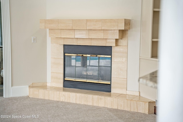 interior details with carpet floors and a tiled fireplace