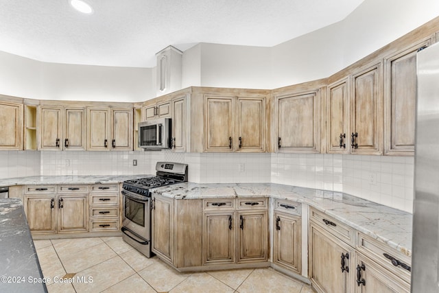 kitchen featuring tasteful backsplash, light stone counters, and stainless steel appliances