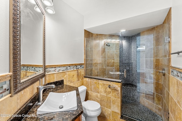 bathroom featuring vanity, an enclosed shower, tile walls, and toilet