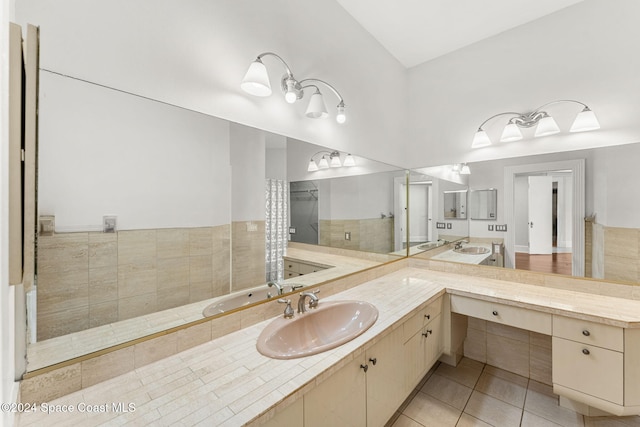 bathroom with tile patterned flooring, vanity, and walk in shower