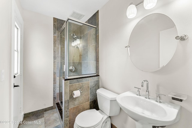 bathroom featuring toilet, an enclosed shower, and sink