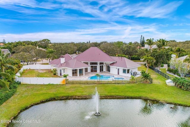 back of property featuring a yard, a water view, and a sunroom