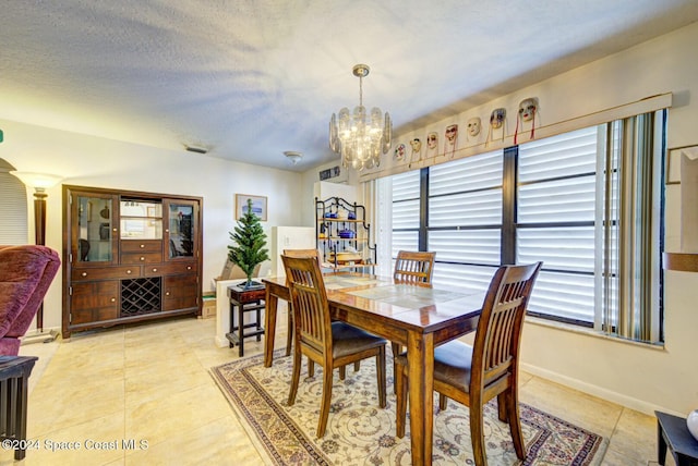 dining room featuring a textured ceiling, an inviting chandelier, and light tile patterned flooring