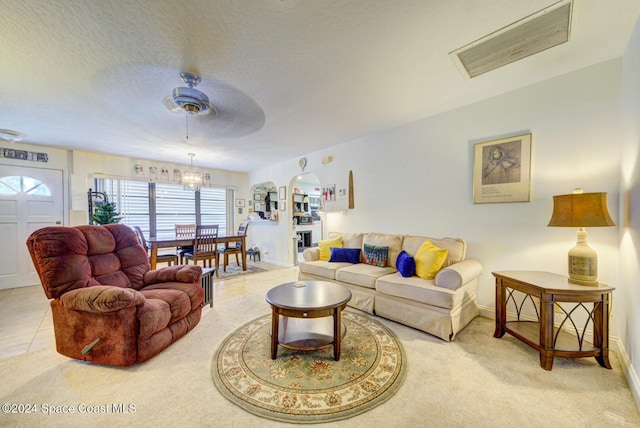 tiled living room with a textured ceiling and ceiling fan