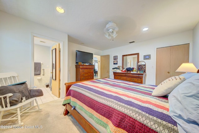 tiled bedroom featuring ensuite bathroom, a closet, and ceiling fan