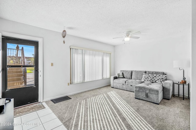 tiled living room with ceiling fan and a textured ceiling