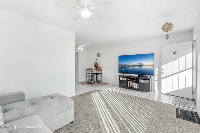 tiled living room with a textured ceiling and ceiling fan