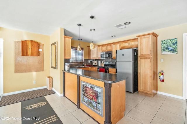 kitchen with appliances with stainless steel finishes, backsplash, sink, light tile patterned floors, and decorative light fixtures