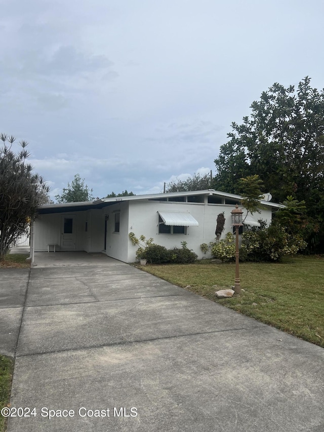 view of front of house with a front yard and a carport