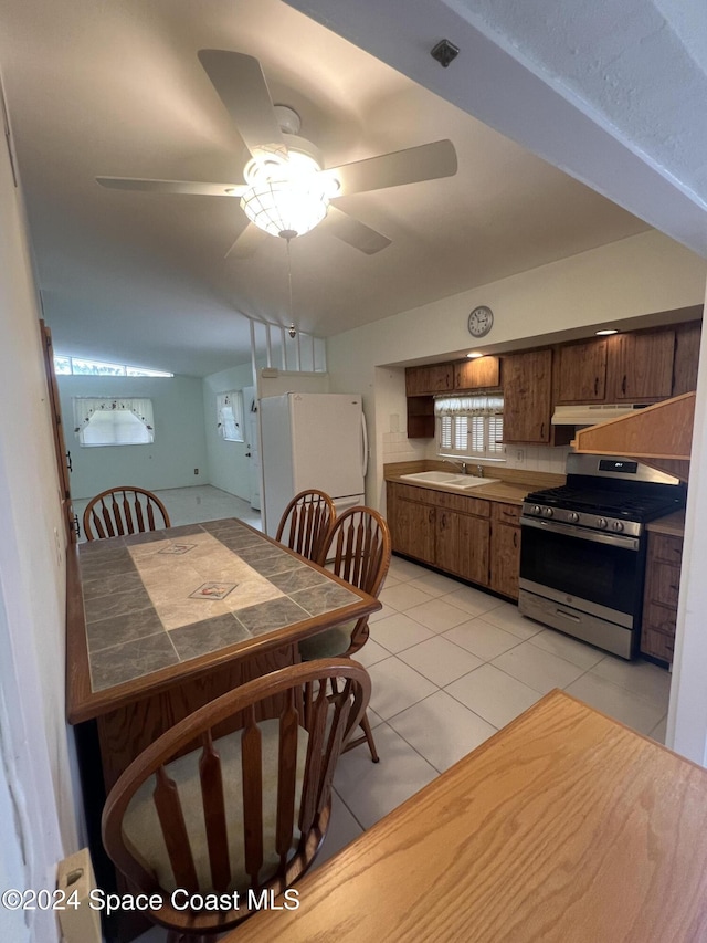 tiled dining room featuring sink and ceiling fan