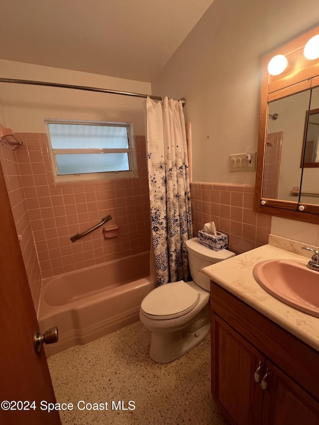 full bathroom featuring vanity, toilet, tile walls, and shower / tub combo with curtain