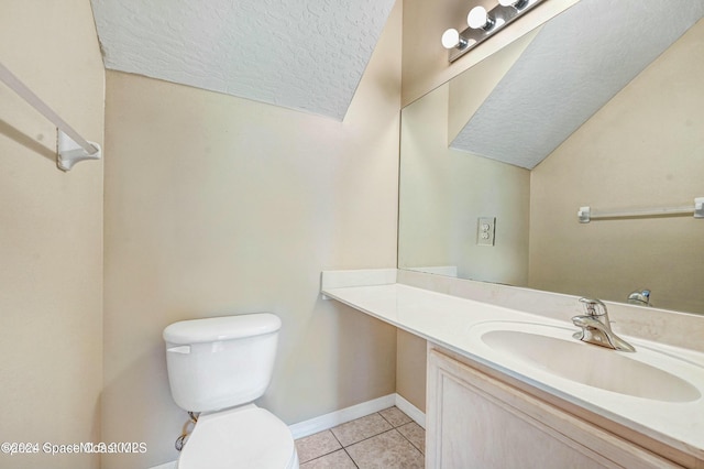 bathroom featuring tile patterned flooring, vanity, a textured ceiling, and toilet