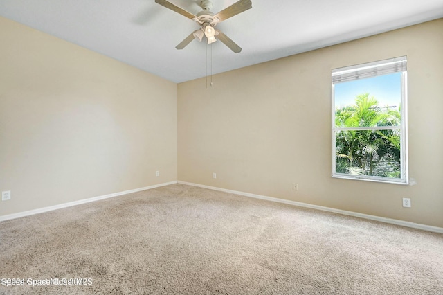 carpeted spare room with plenty of natural light and ceiling fan