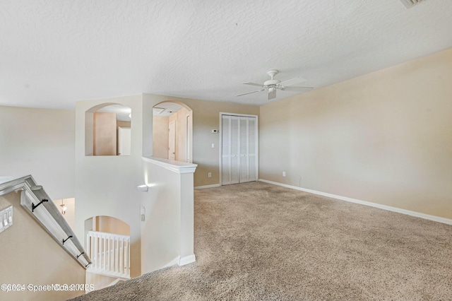 empty room with carpet, a textured ceiling, and ceiling fan