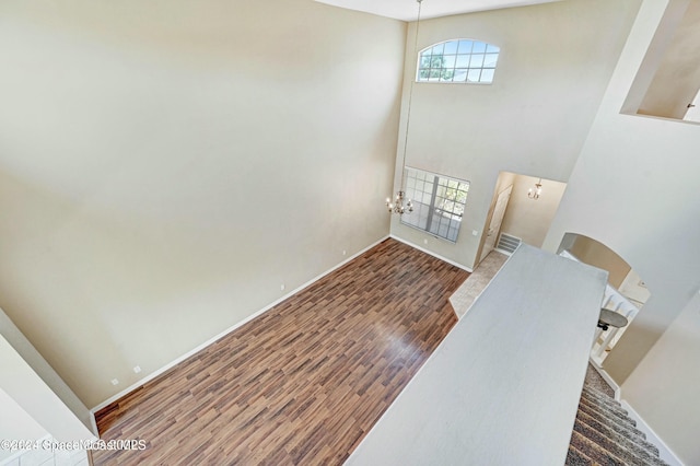 entrance foyer featuring a towering ceiling and dark wood-type flooring