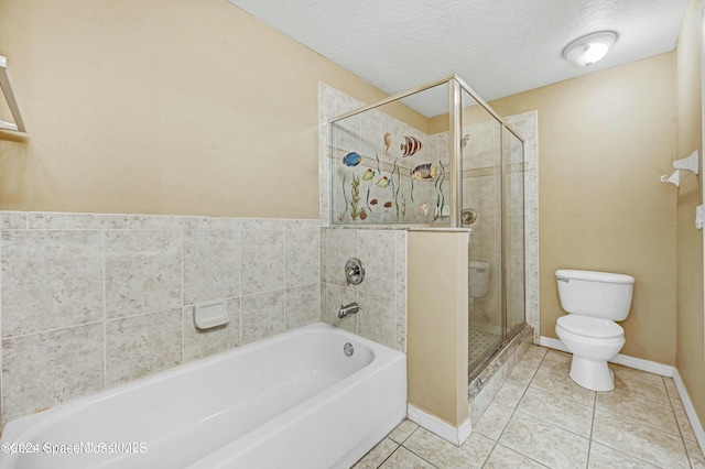 bathroom featuring tile patterned flooring, shower with separate bathtub, toilet, and a textured ceiling