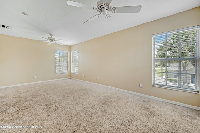 spare room featuring a textured ceiling, carpet floors, plenty of natural light, and ceiling fan