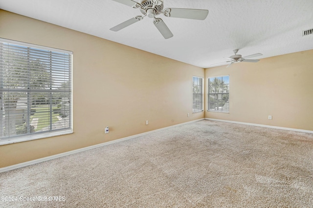 unfurnished room with ceiling fan, carpet floors, and a textured ceiling