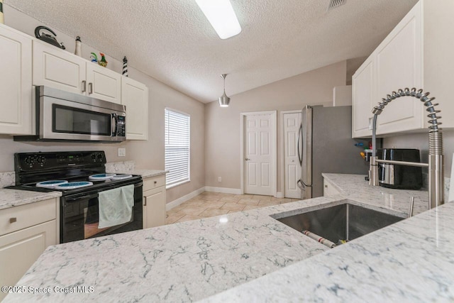 kitchen featuring vaulted ceiling, white cabinetry, appliances with stainless steel finishes, and light stone countertops