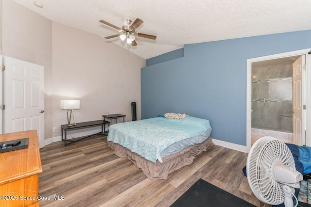 bedroom featuring lofted ceiling, connected bathroom, dark hardwood / wood-style floors, and a textured ceiling