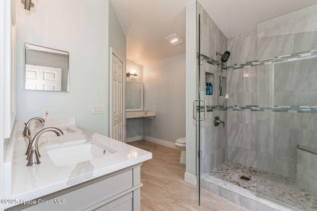 bathroom with vanity, toilet, and a shower with door