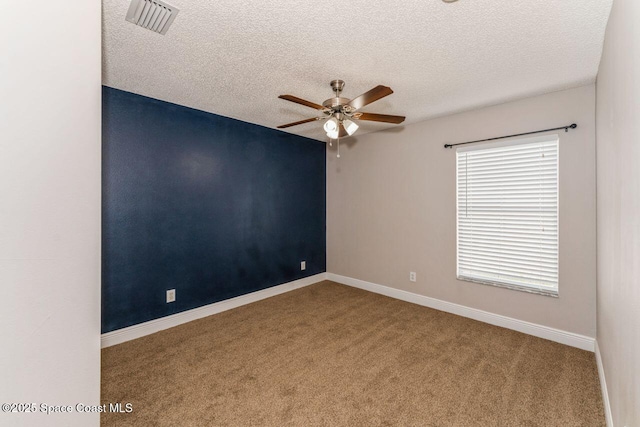 spare room with ceiling fan, a textured ceiling, and carpet flooring