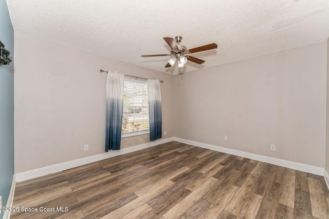 spare room featuring dark hardwood / wood-style flooring, ceiling fan, and a textured ceiling