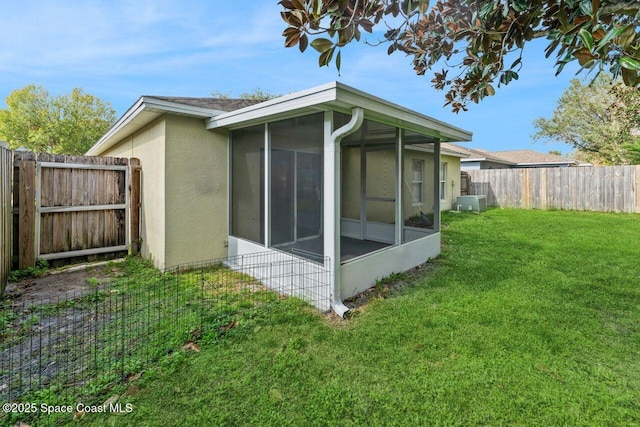 view of side of home featuring a lawn and a sunroom