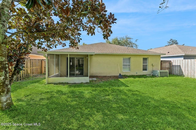 back of property featuring a sunroom, a yard, and central air condition unit