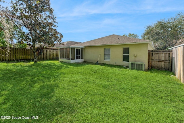 back of property with central AC, a lawn, and a sunroom