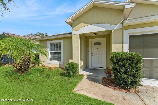 property entrance with a garage and a lawn